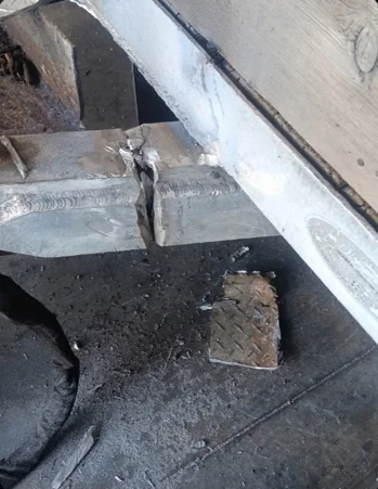 Repaired aluminum crossmember weld under a trailer