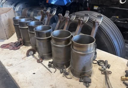 Cylinder liners and connecting rods removed from a semi truck diesel engine